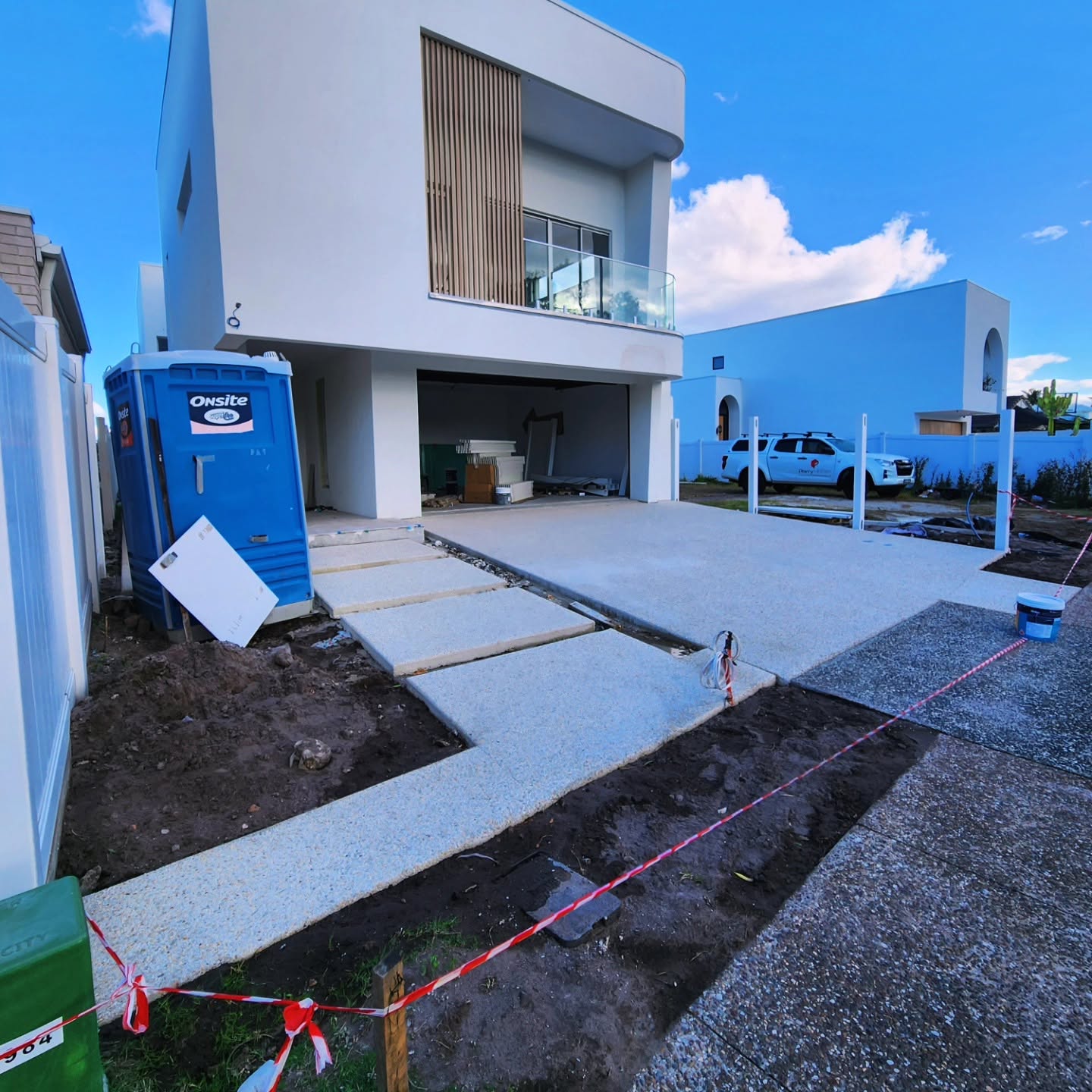 A new concrete driveway and stepping path poured by Azcon at a modern two storey home