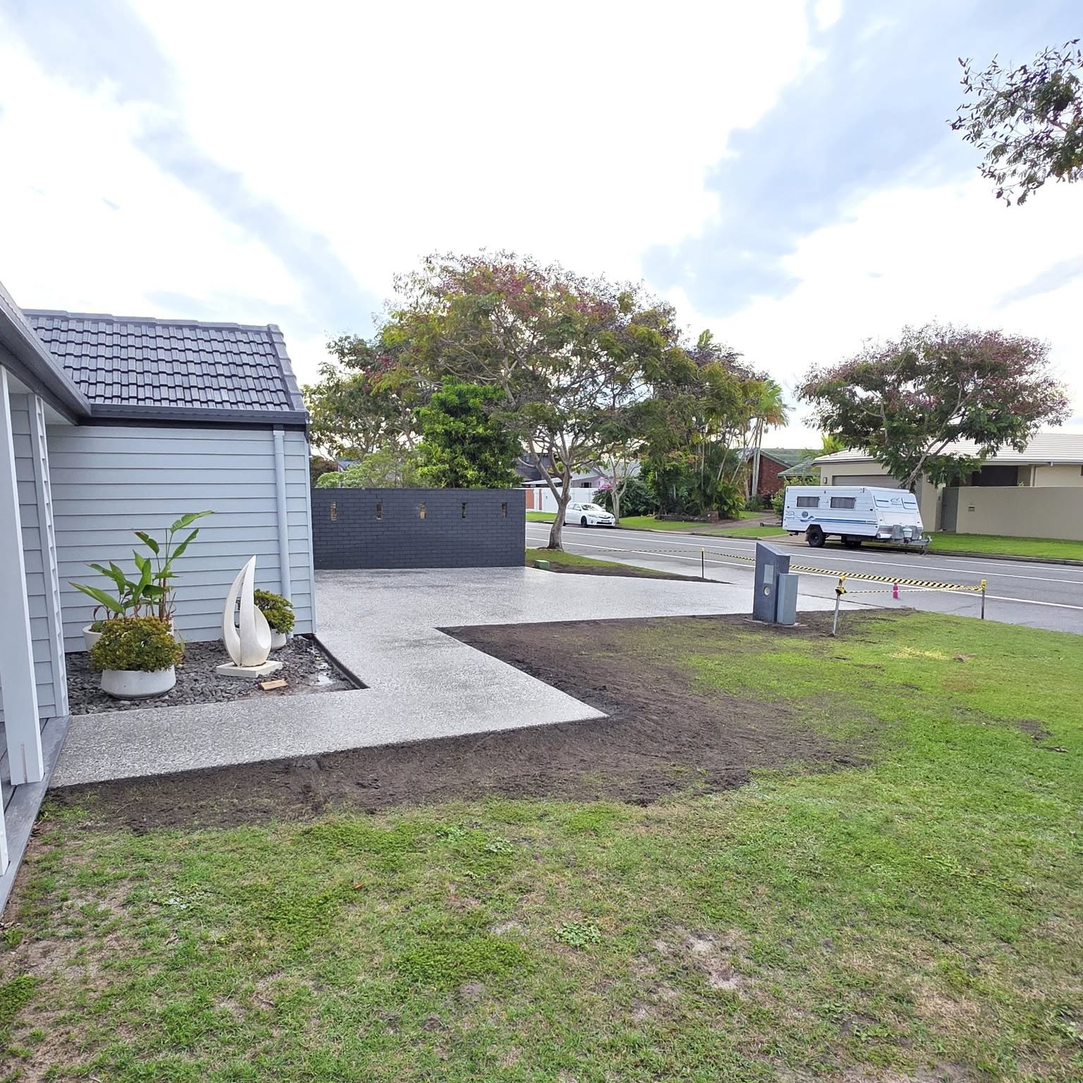 Wide concrete path wrapping around the side of a house