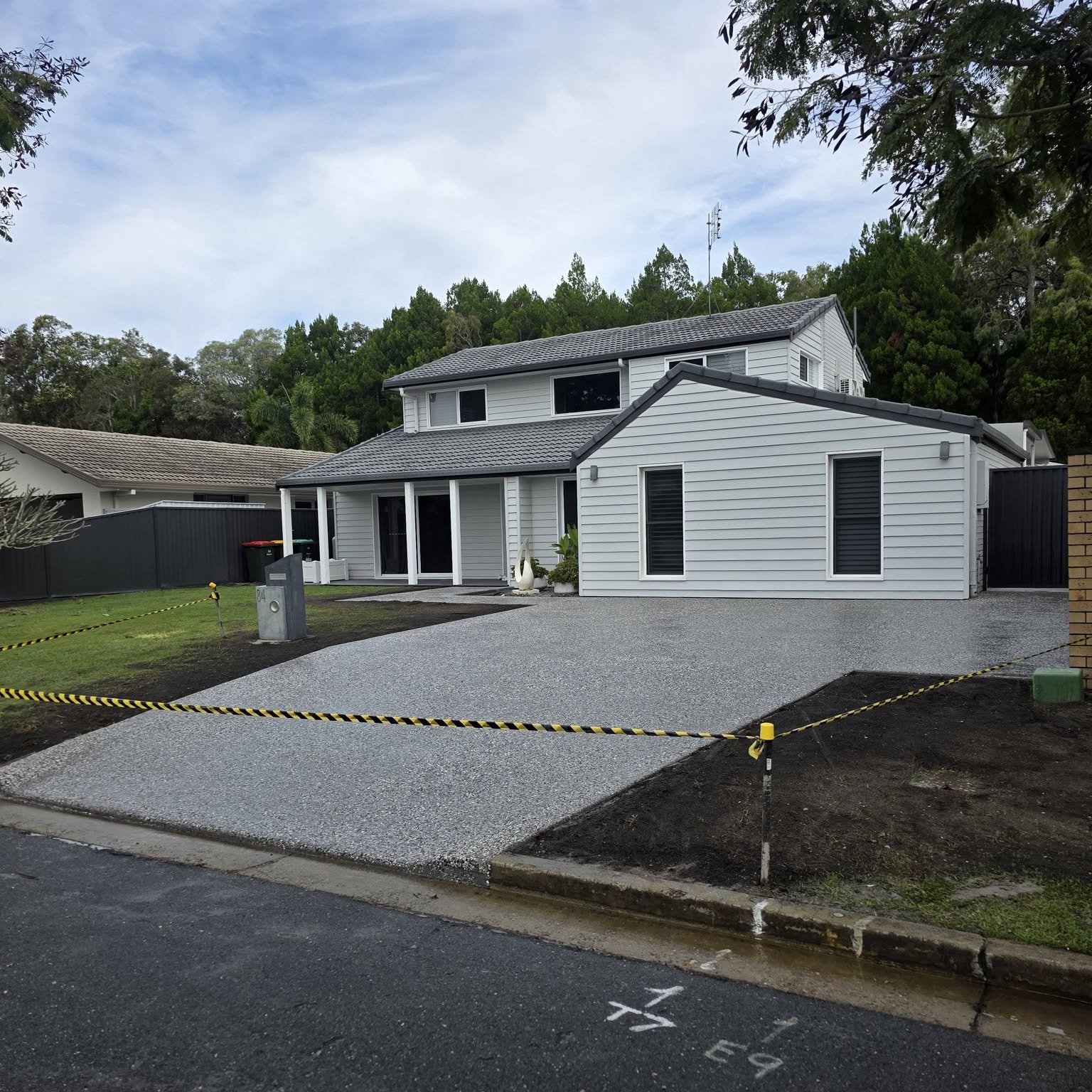 Full frontage of a weatherboard home with a new exposed aggregate driveway